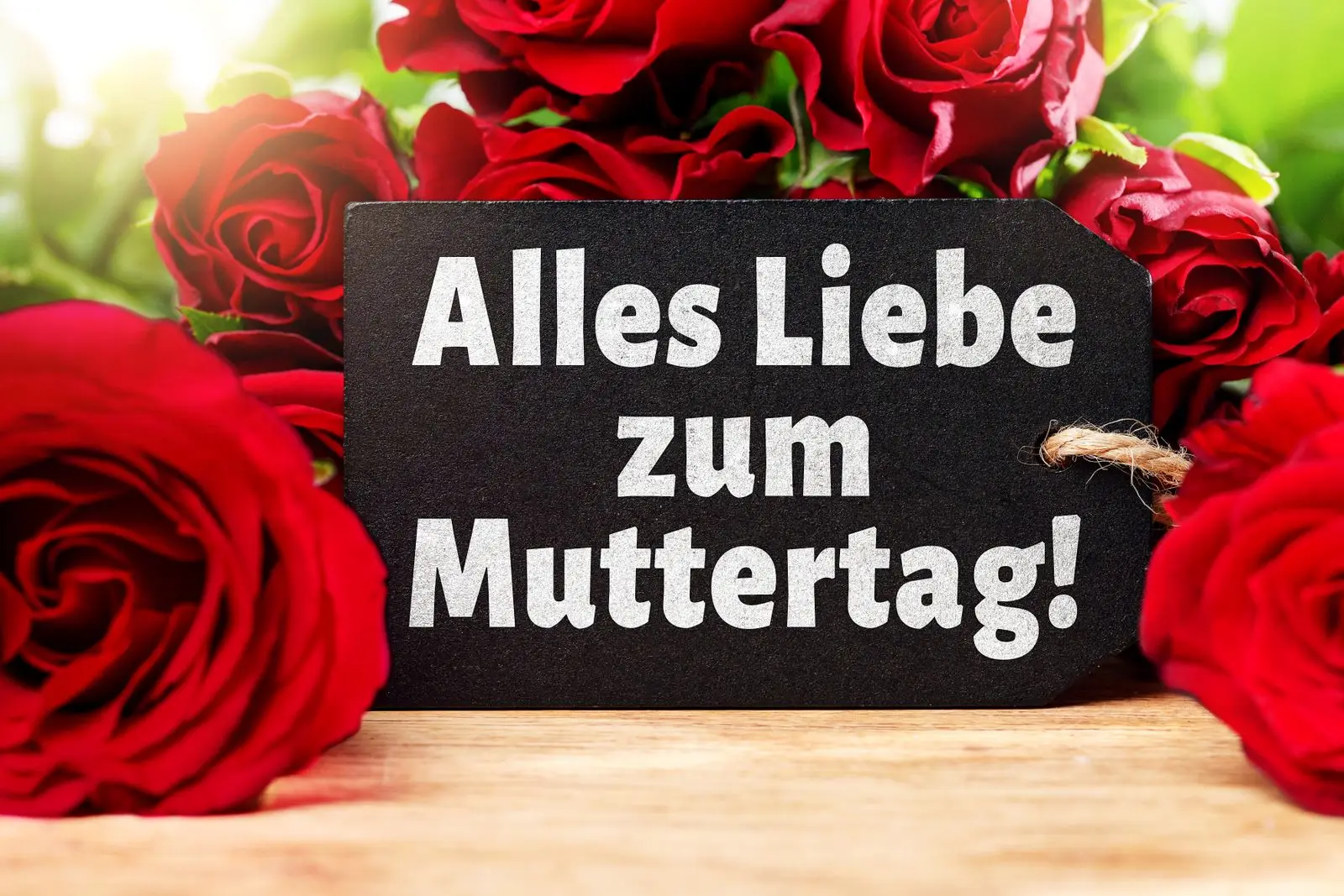 Alles liebe zum muttertag neben roten rosen