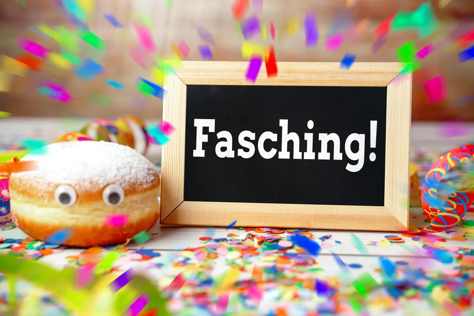 Fasching bunte dekoration mit konfetti und faschingskrapfen für die närrische zeit.