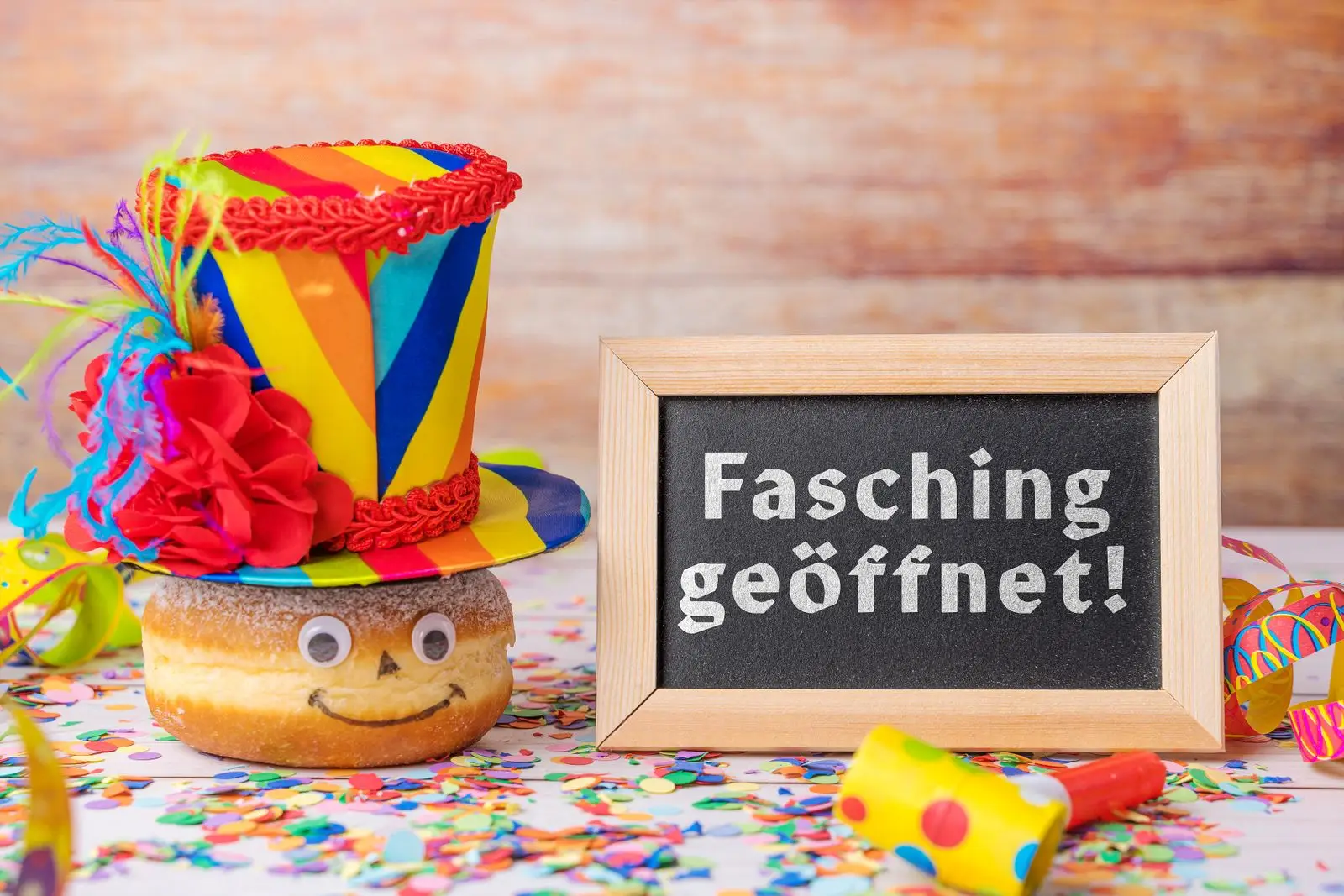 Fasching geöffnet lustiger krapfen mit buntem hut und konfetti für die närrische zeit