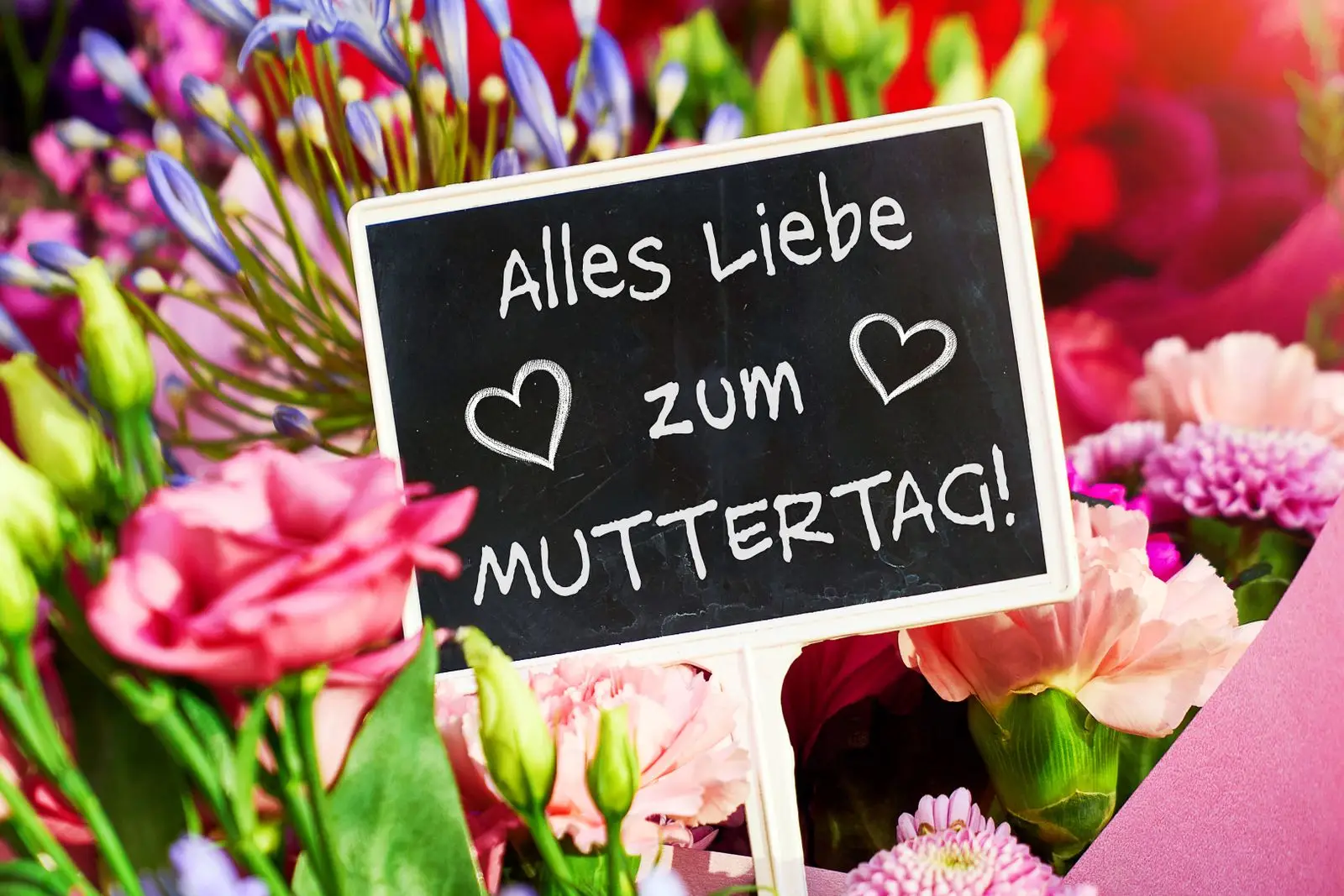Muttertagsgruß auf schild in blumenstrauß
