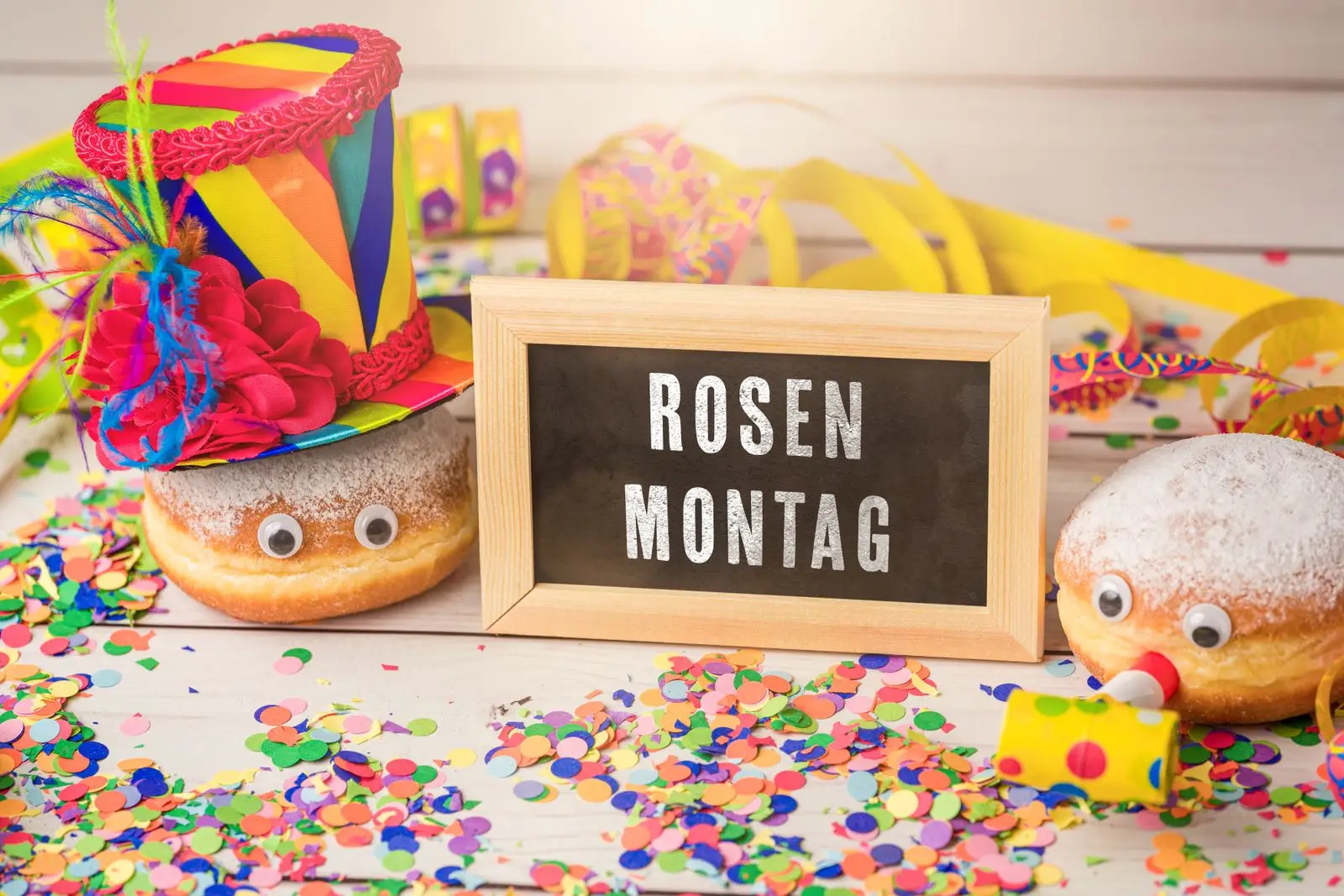 Rosenmontag 1 rosenmontag steht auf einem schild neben faschingsdeko und krapfen Rosenmontag steht auf einem schild neben faschingsdeko und krapfen