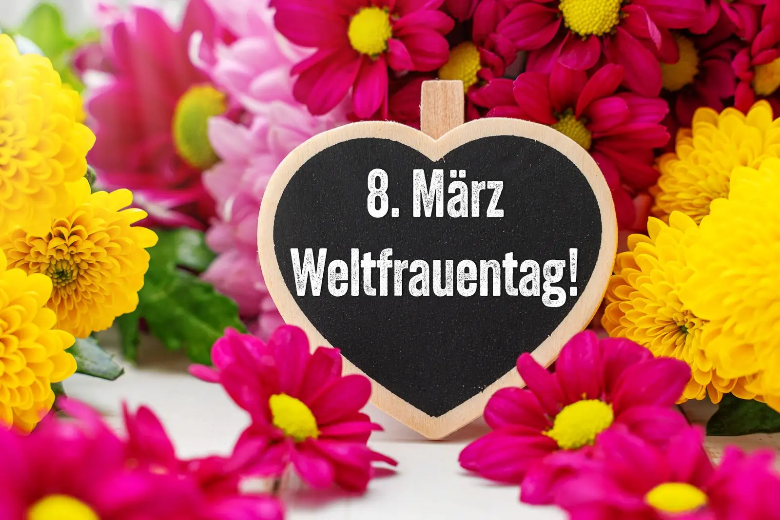 Bild zum frauentag mit herztafel und blumen