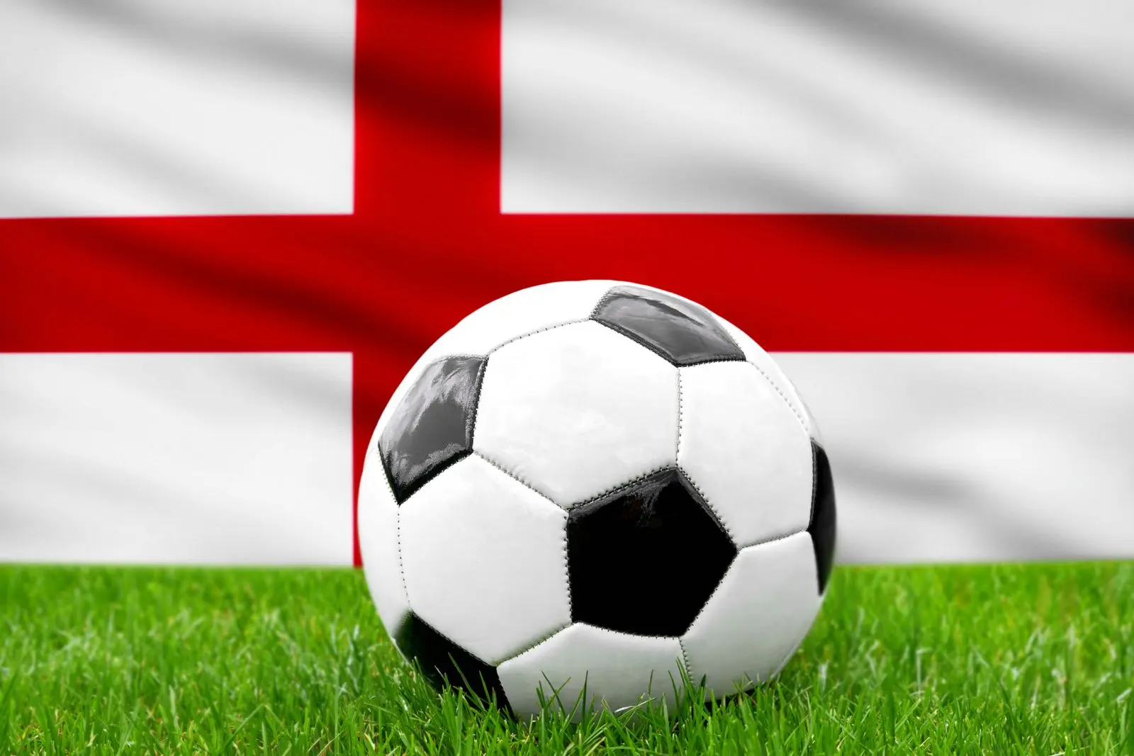 Ein fusball vor der englischen fahne steht fur die nationalmannschaft von england im fusball