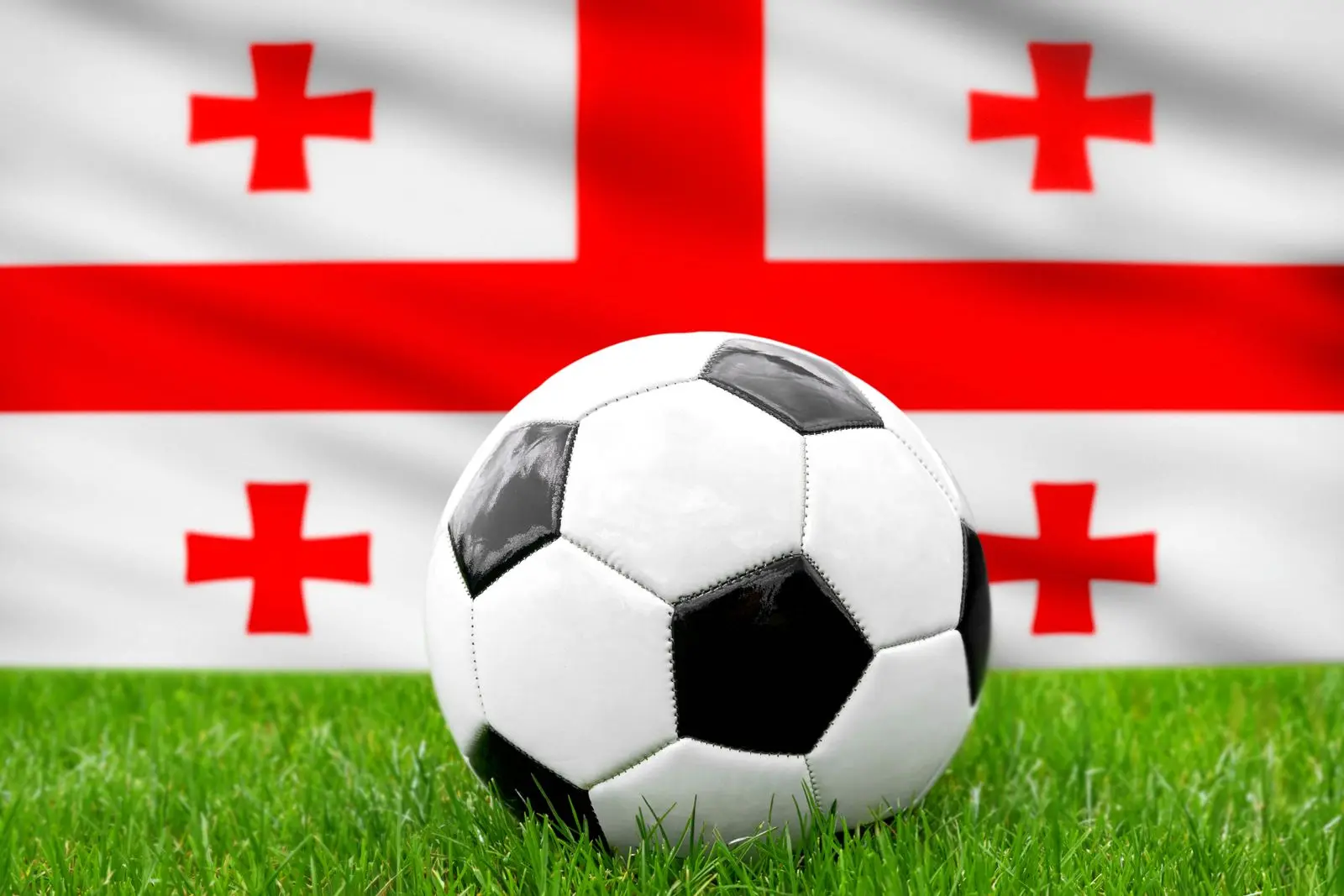 Ein fußball vor der georgischen fahne repräsentiert die nationalmannschaft von georgien im fußball.