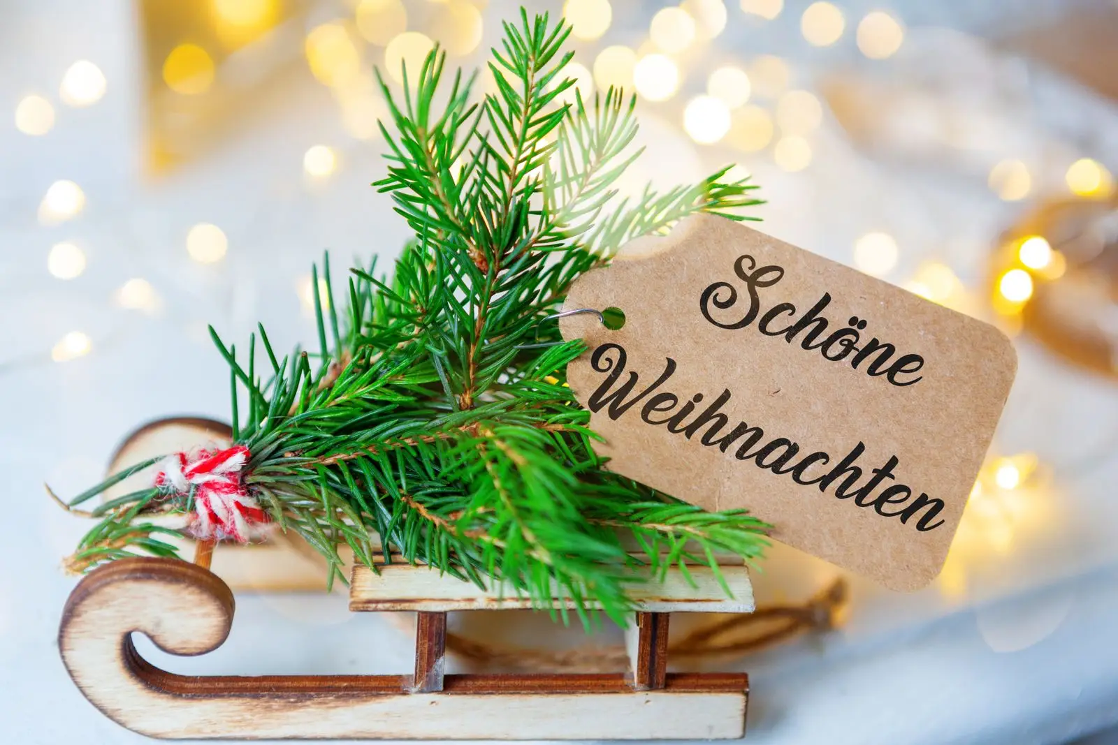Schöne weihnachten auf holzschlitten mit tannenzweig und festlicher weihnachtsdeko.