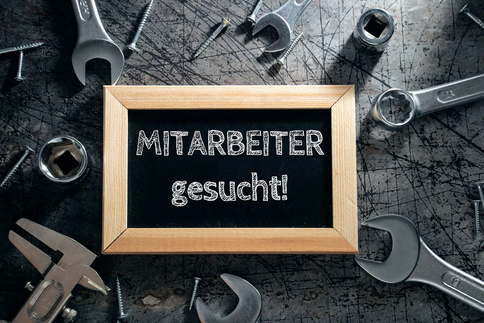 Tafel „mitarbeiter gesucht! “ auf werkbank mitarbeiter gesucht.