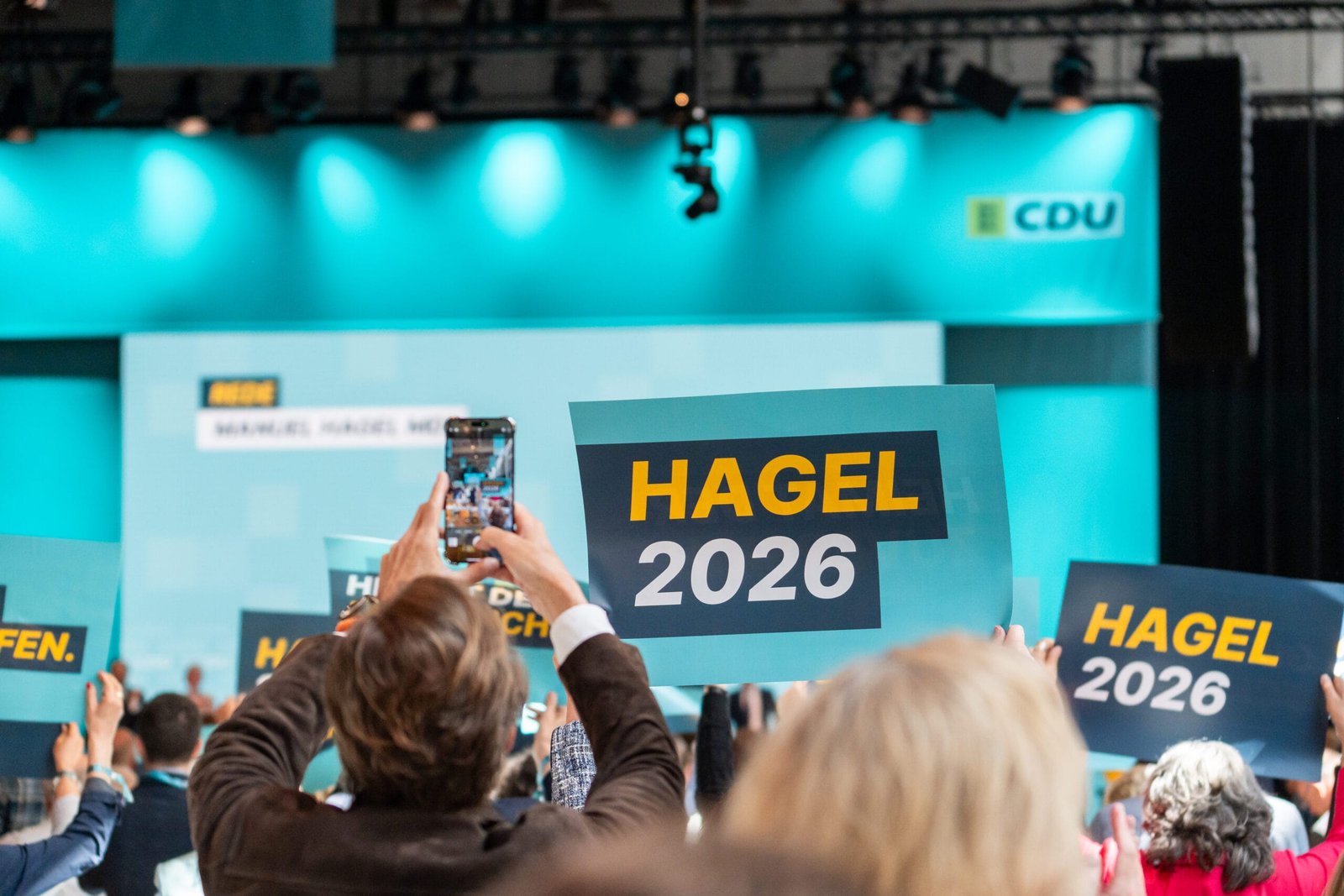 Cdu-landesparteitag in stuttgart: kanzler merz schwört landespartei auf wahljahr 2026 ein 2 cdu parteitag scaled Parteimitglieder jubeln und halten plakate mit aufschrift: gutes schaffen, hagel 2026, heimat der innovation nach der rede von manuel hagel hoch
