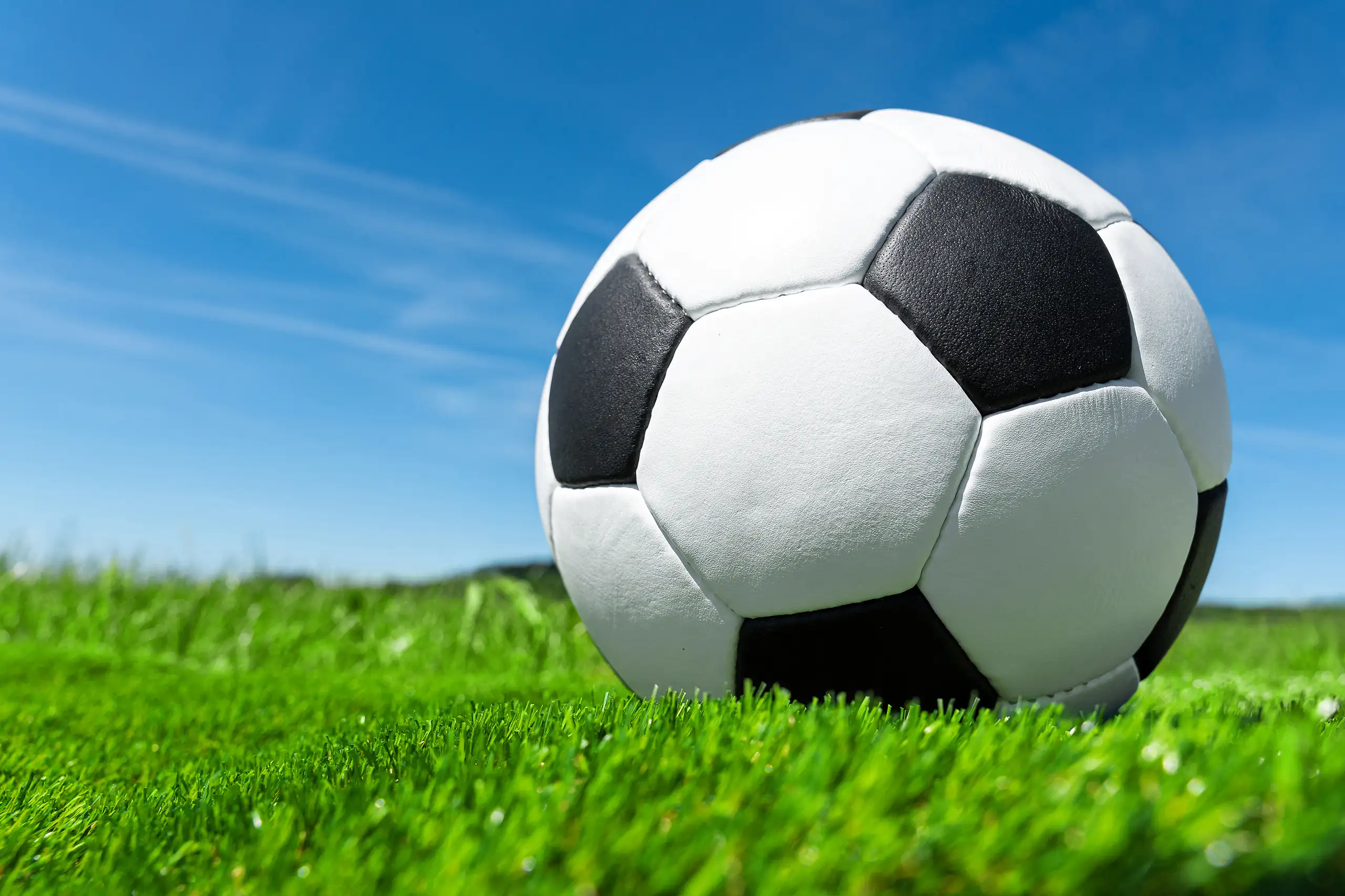 Fußball bilder mit fußball auf gepflegtem rasen und blauem himmel für berichte, ergebnisse und spieltage
