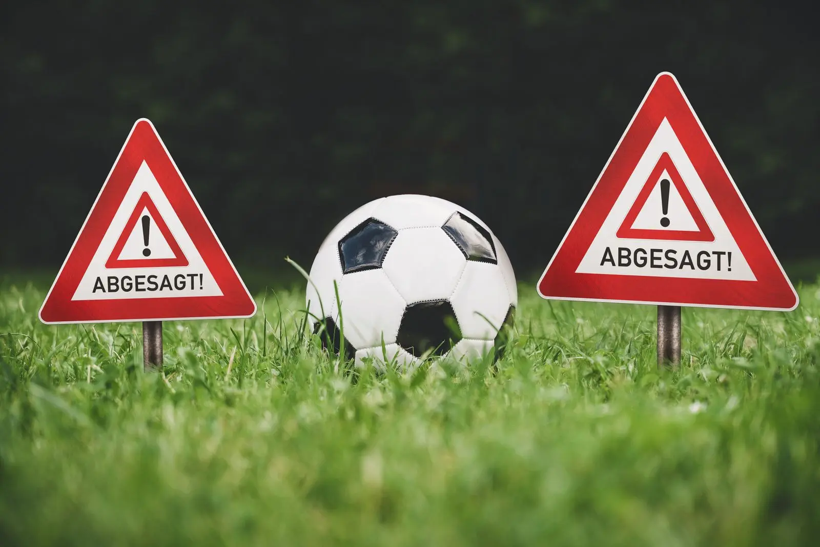 Fußball abgesagt wegen wetter oder platzsperre mit fußball auf rasen und warnschildern zum spielausfall