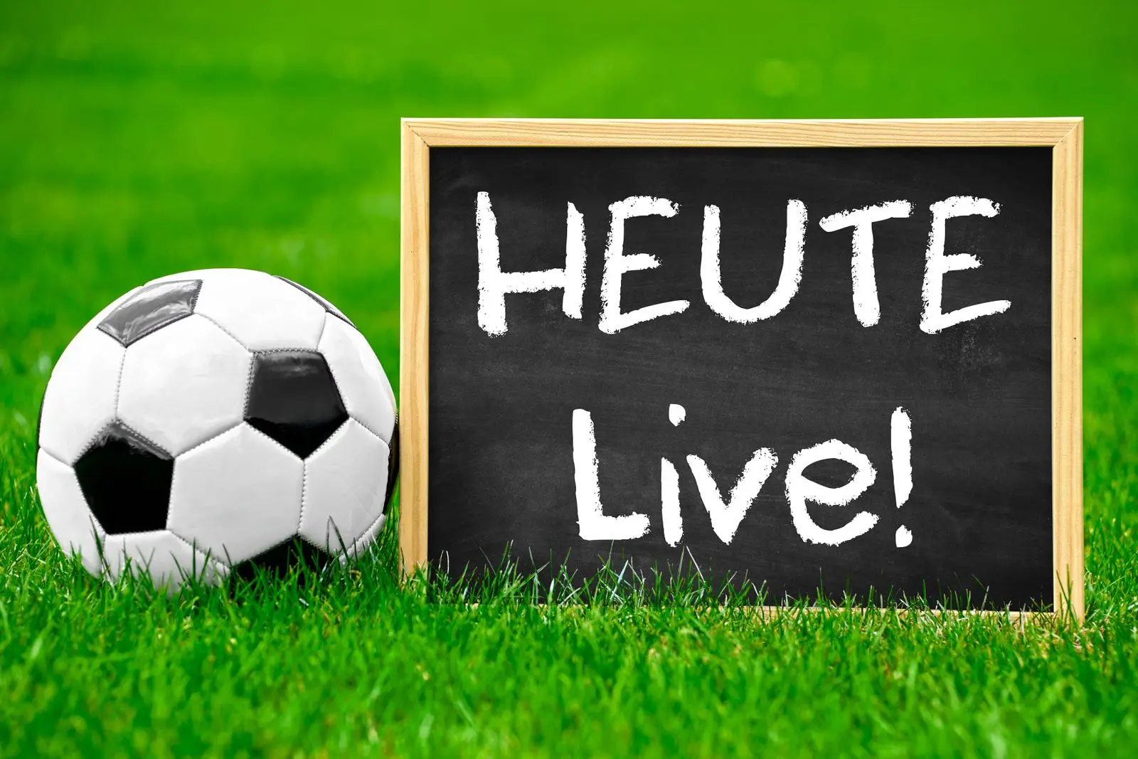 Fußball heute live übertragung auf dem sportplatz mit fußball als symbol für liveergebnisse und tv-übertragung