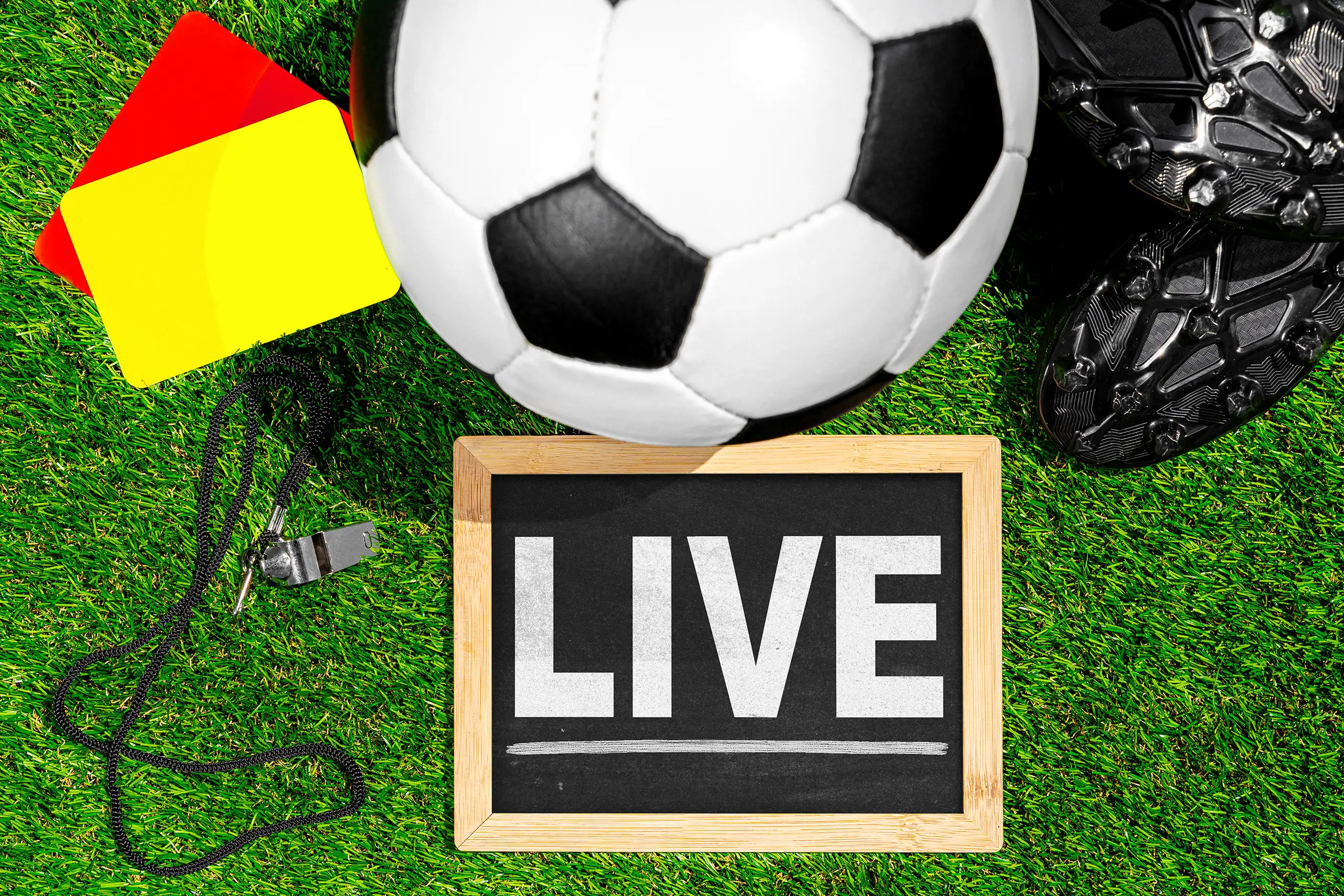 Fußballspiel live mit ball und schiedsrichterausrüstung auf dem rasen als symbol für liveticker und ergebnisse im fußballbereich.