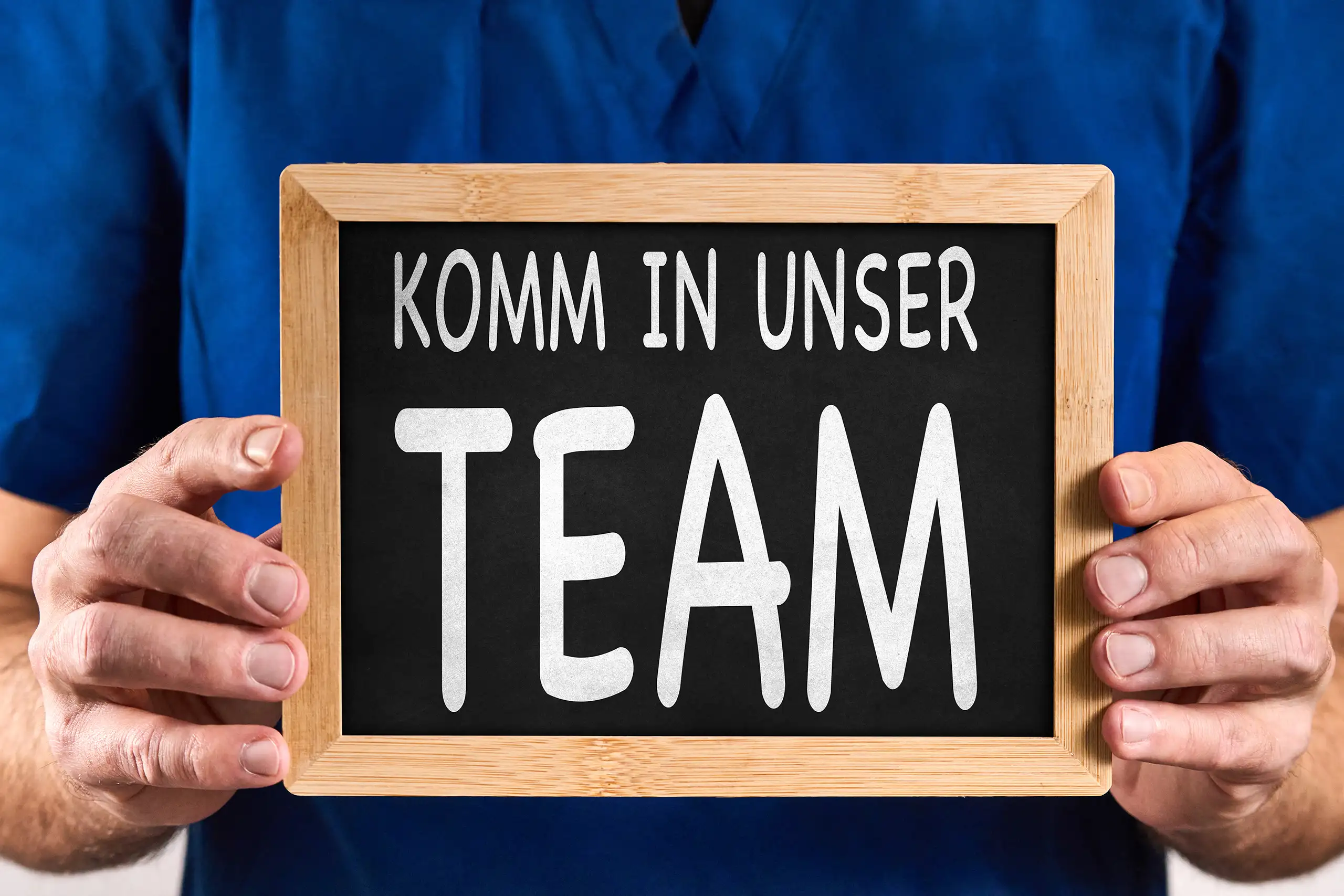 Arztpraxis mitarbeiter gesucht 1 komm in unser team arzt Arzt hält tafel mit aufschrift: komm in unser team.