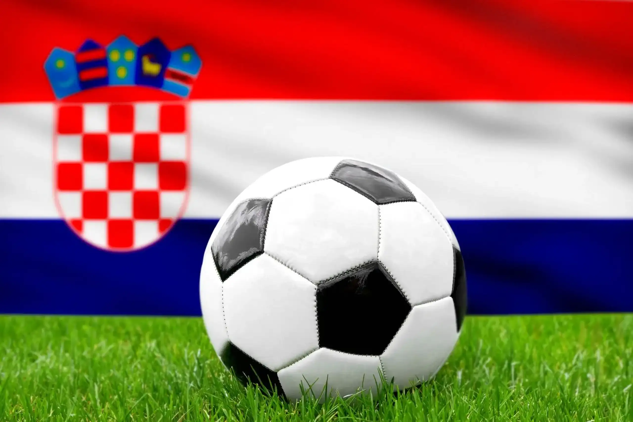 Kroatien fußball nationalmannschaft mit fußball vor kroatischer flagge auf grünem rasen