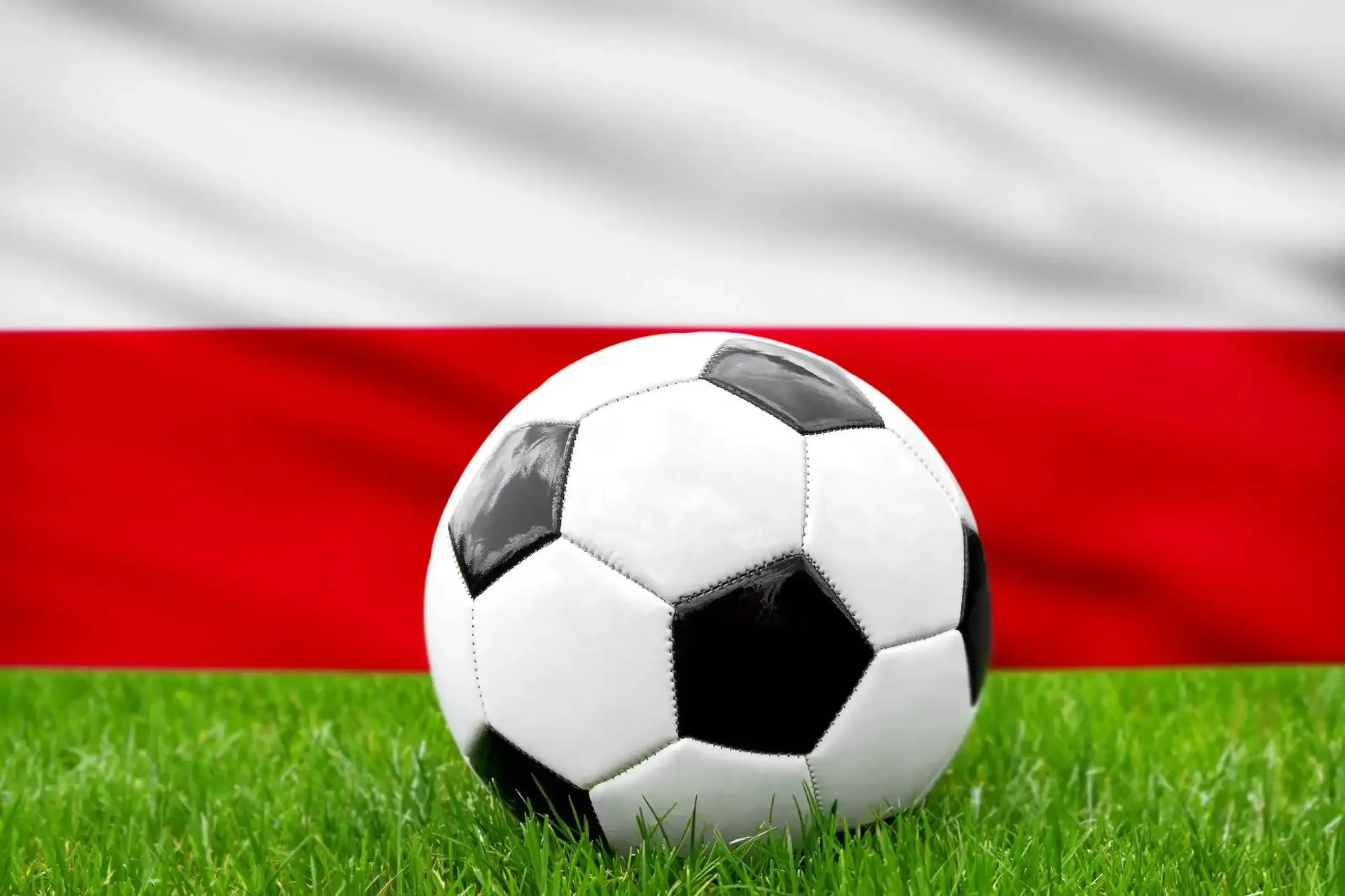 Polen fußball nationalmannschaft mit fußball vor polnischer flagge auf grünem rasen