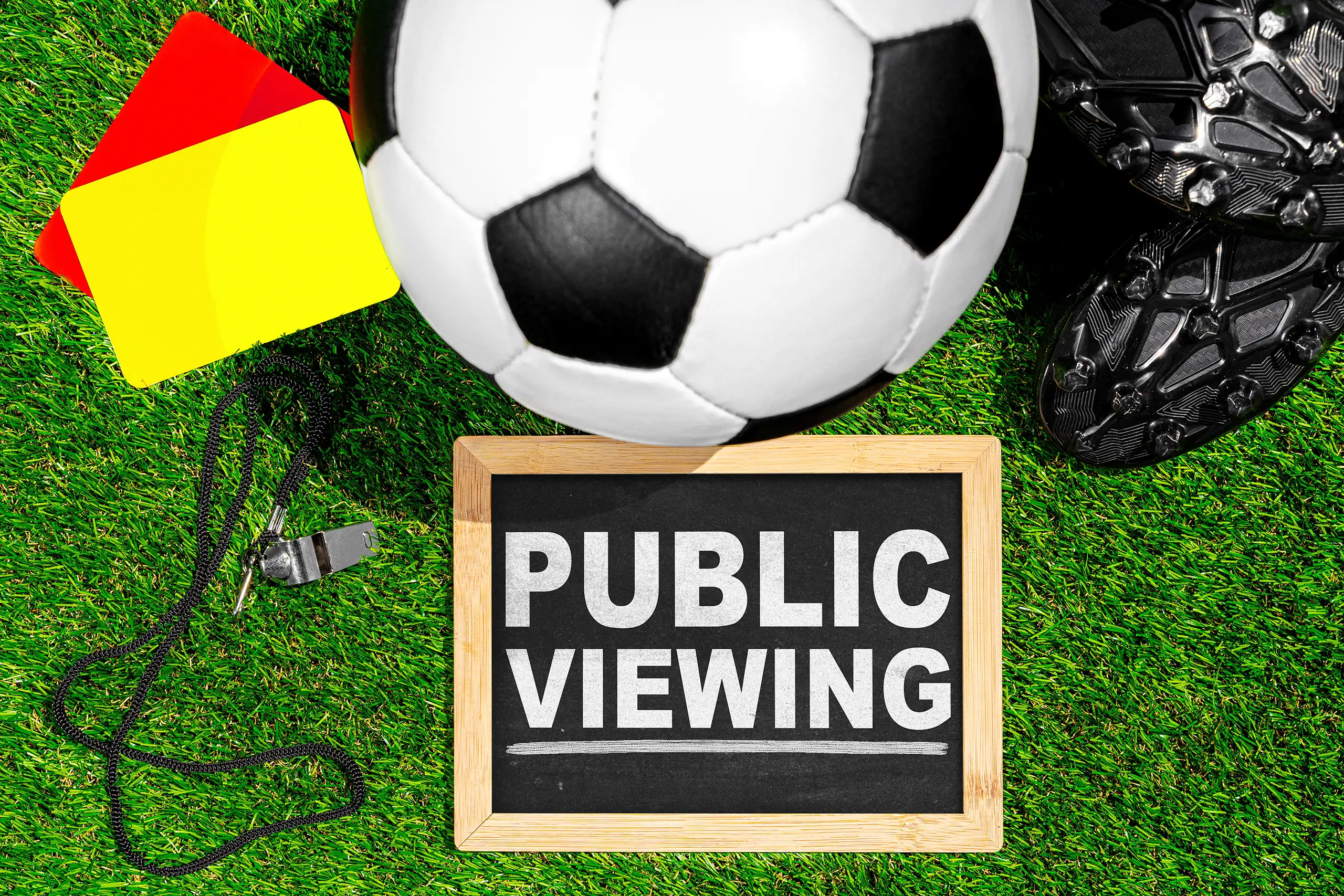 Public viewing fußball mit ball und schiedsrichterausrüstung als symbol für liveübertragung und fanveranstaltung in deutschland