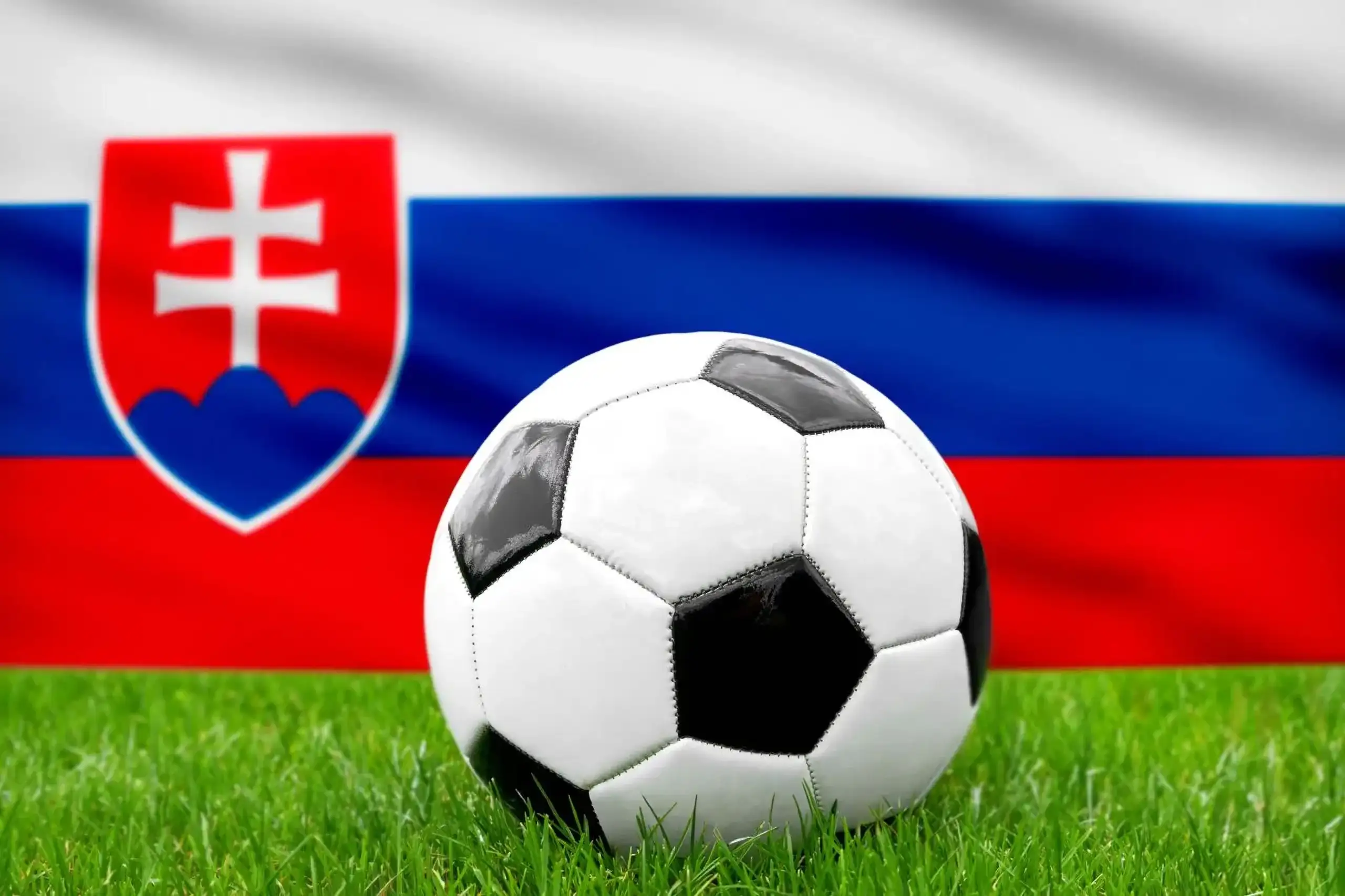 Slowakei fußball nationalmannschaft mit fußball vor slowakischer flagge auf grünem rasen