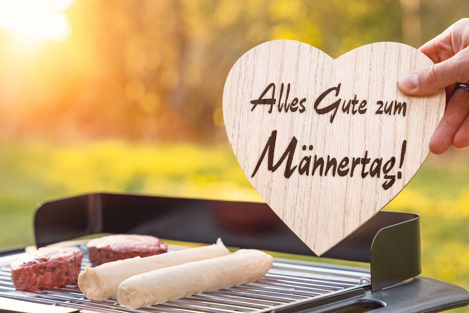 Alles gute zum männertag! Schriftzug auf einem herz über einem grill