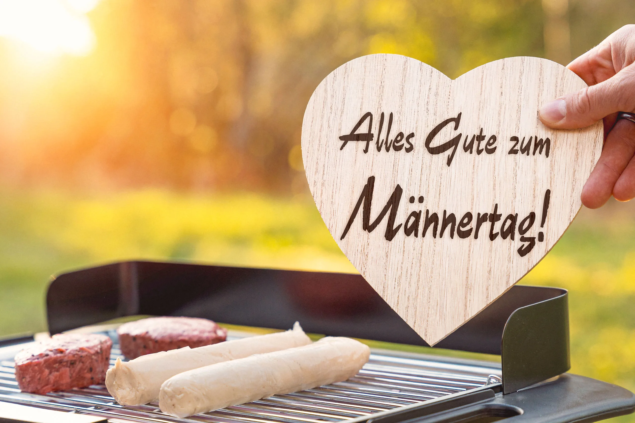 Alles gute zum männertag! Schriftzug auf einem herz über einem grill