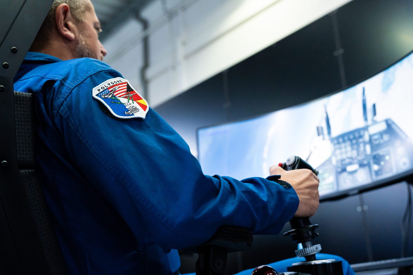 Ein pilot sitzt im simulator und steuert ein flugzeug während der präsentation des ki-luftkampfsystems centaur im helsing ai agent for air combat simulator