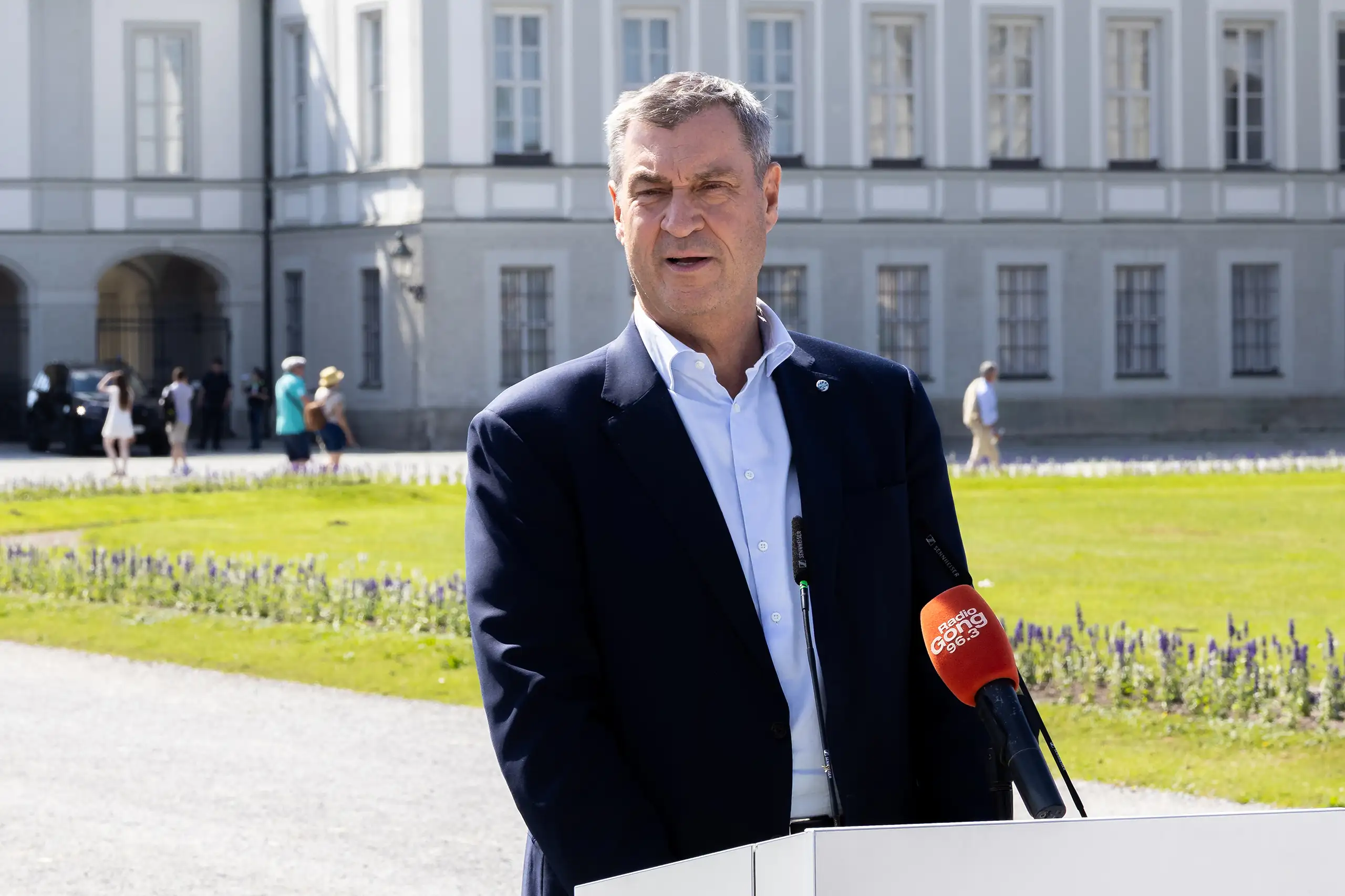 Ministerpräsident markus söder spricht vor medienmikrofonen am schloss nymphenburg über die bewerbung münchen 20xx