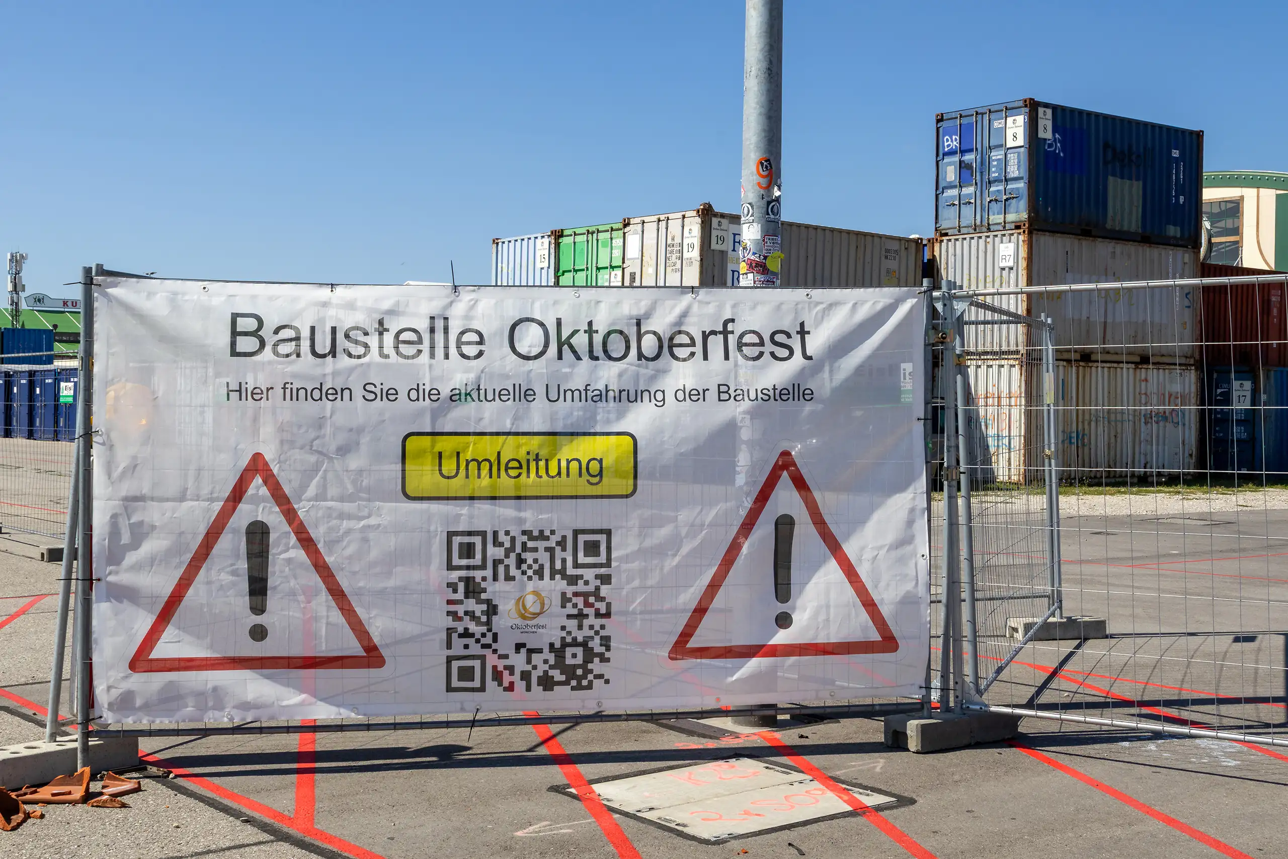 Banner mit der aufschrift baustelle oktoberfest und umleitung vor containern auf der theresienwiese
