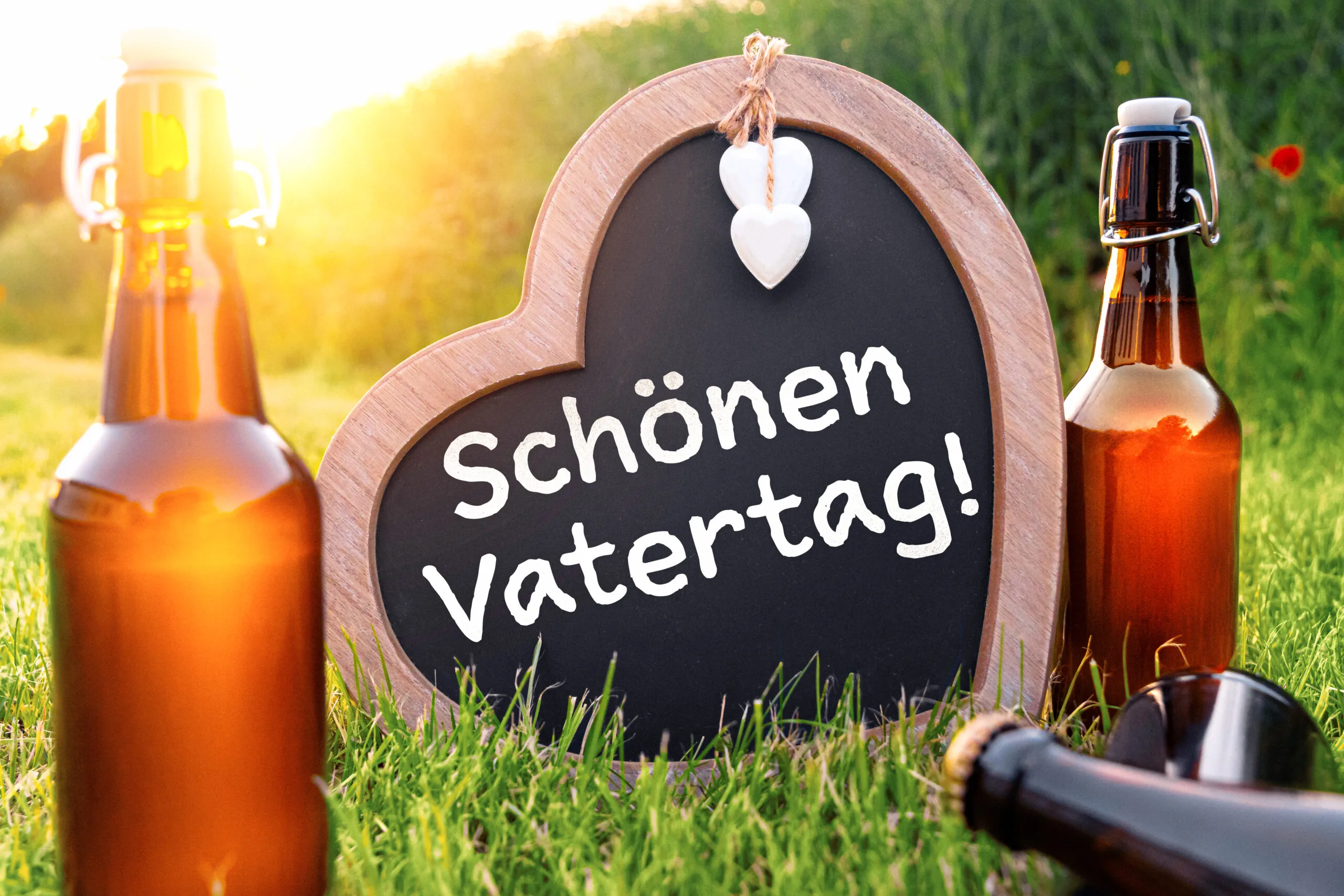 Schönen vatertag gruß mit bierflaschen und herz auf einer wiese